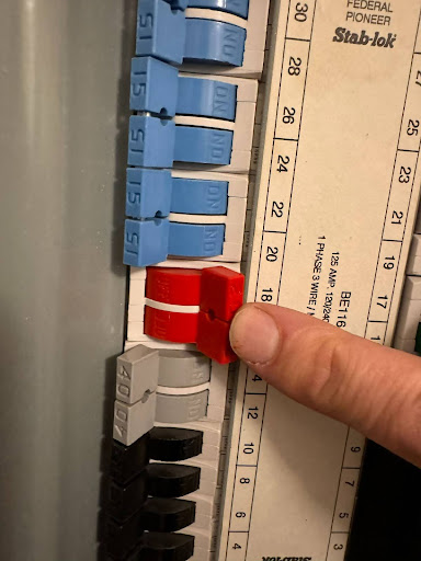 A finger flipping an electrical breaker switch.